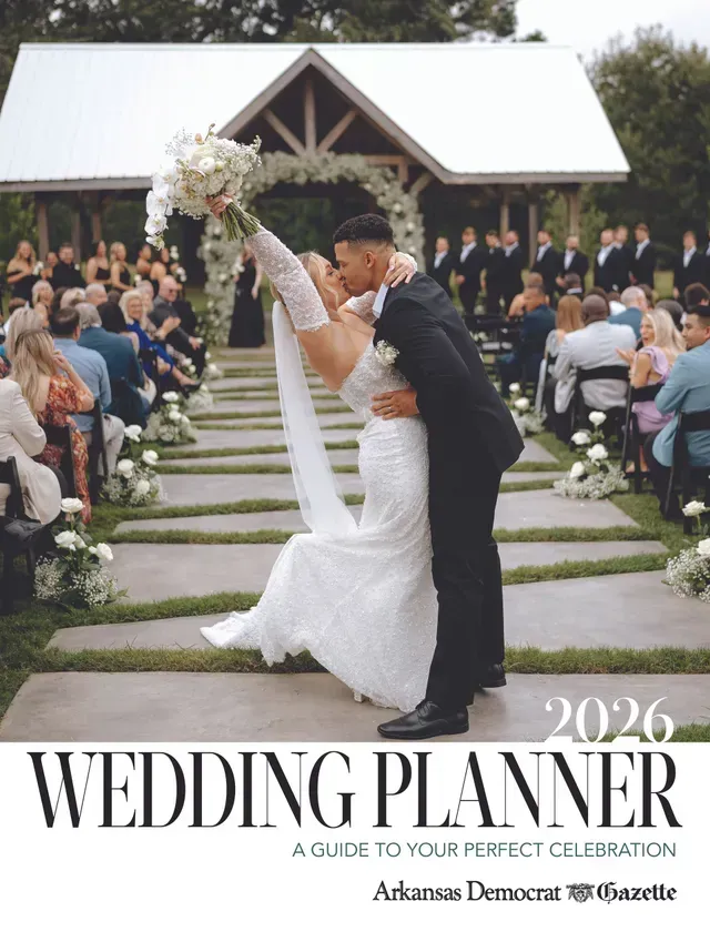 A couple kisses while dipping during their outdoor wedding ceremony on a stone aisle, under the title 2026 Wedding Planner.