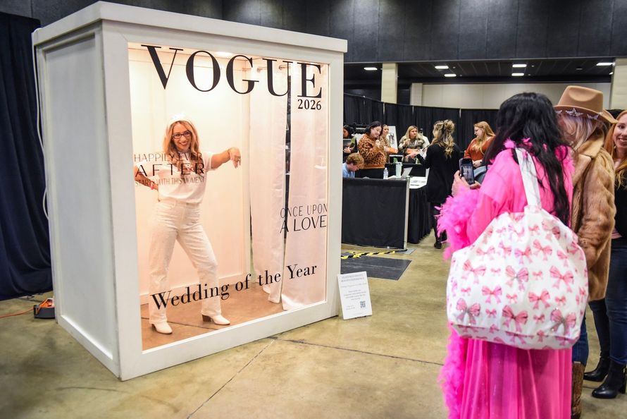 A person poses inside a custom photo booth designed to look like a 