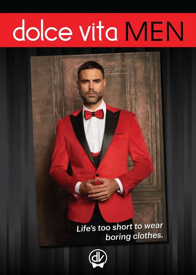 A man wearing a red tuxedo jacket and bow tie stands against a dark background with the text, 