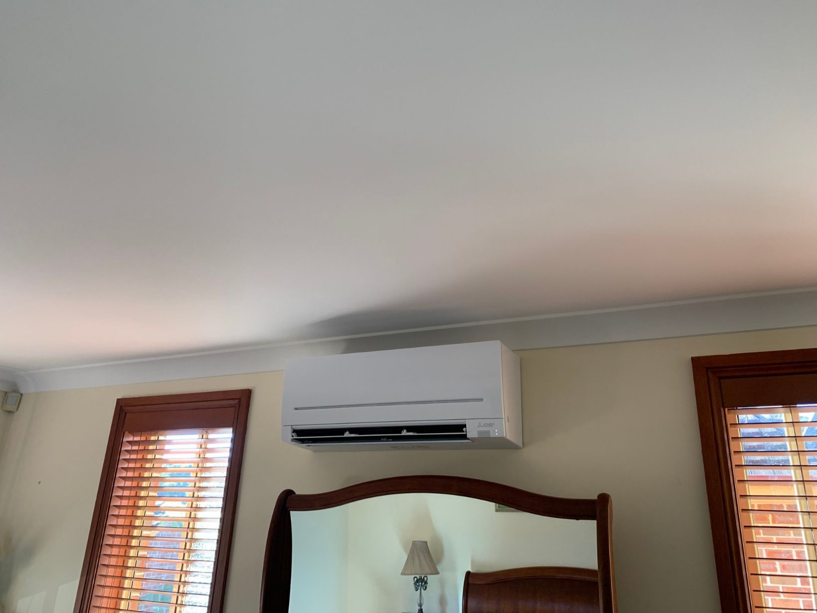 A Mirror And An Air Conditioner Hanging From The Ceiling — Rapidcool Air Conditioning & Electrical In Wollongong, NSW