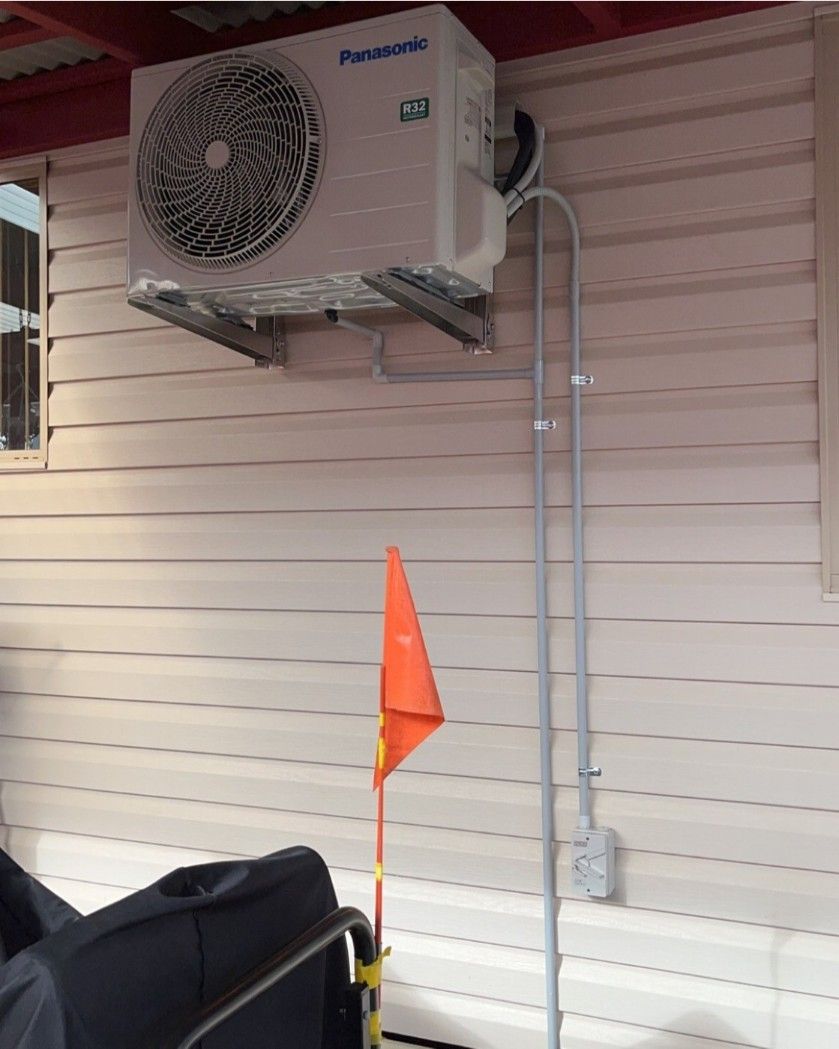 A Panasonic Air Conditioner Is Mounted On The Side Of A Building — Rapidcool Air Conditioning & Electrical In Dapto, NSW