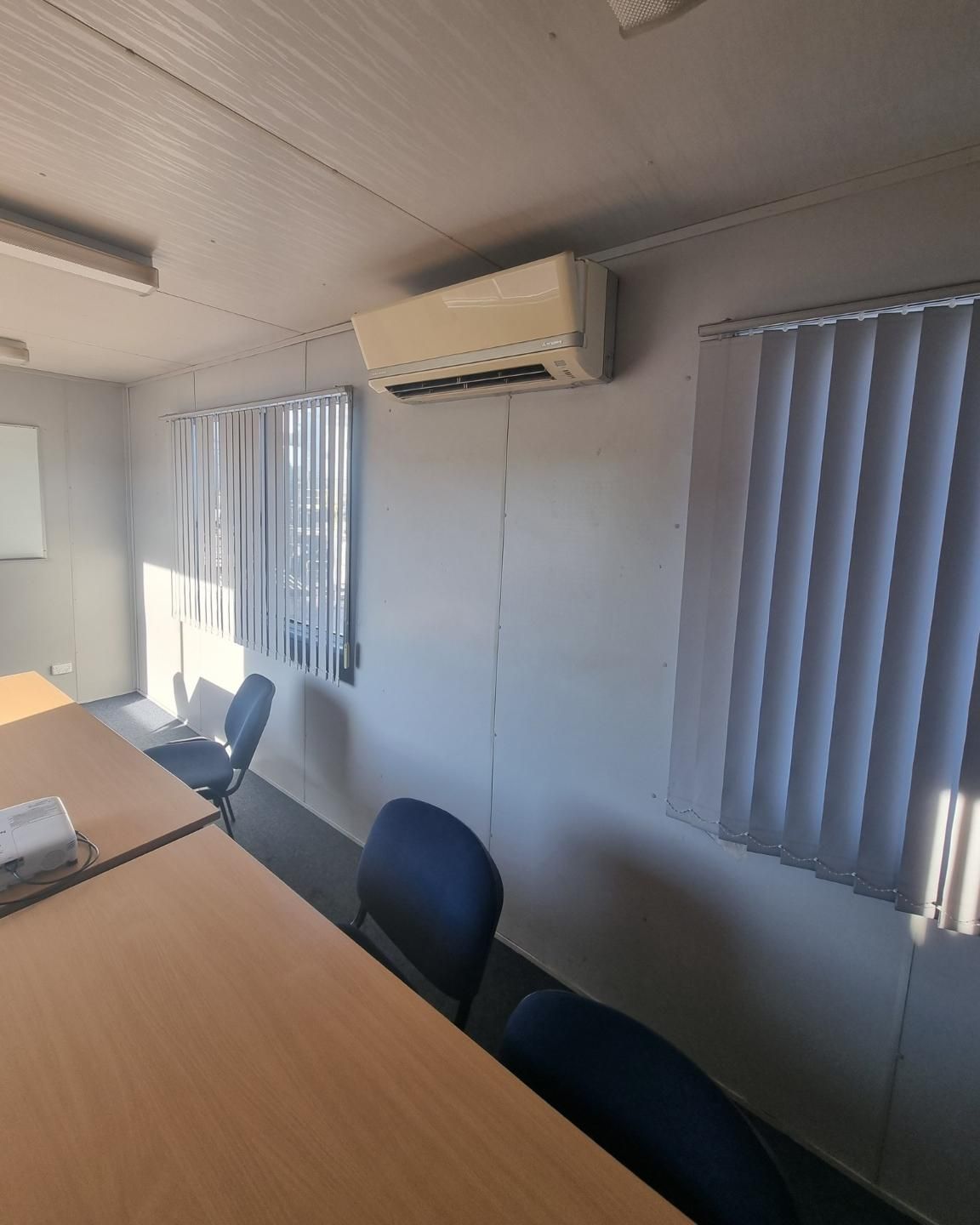 A Conference Room With Tables And Chairs And A Ceiling Fan — Rapidcool Air Conditioning & Electrical In Shellharbour, NSW