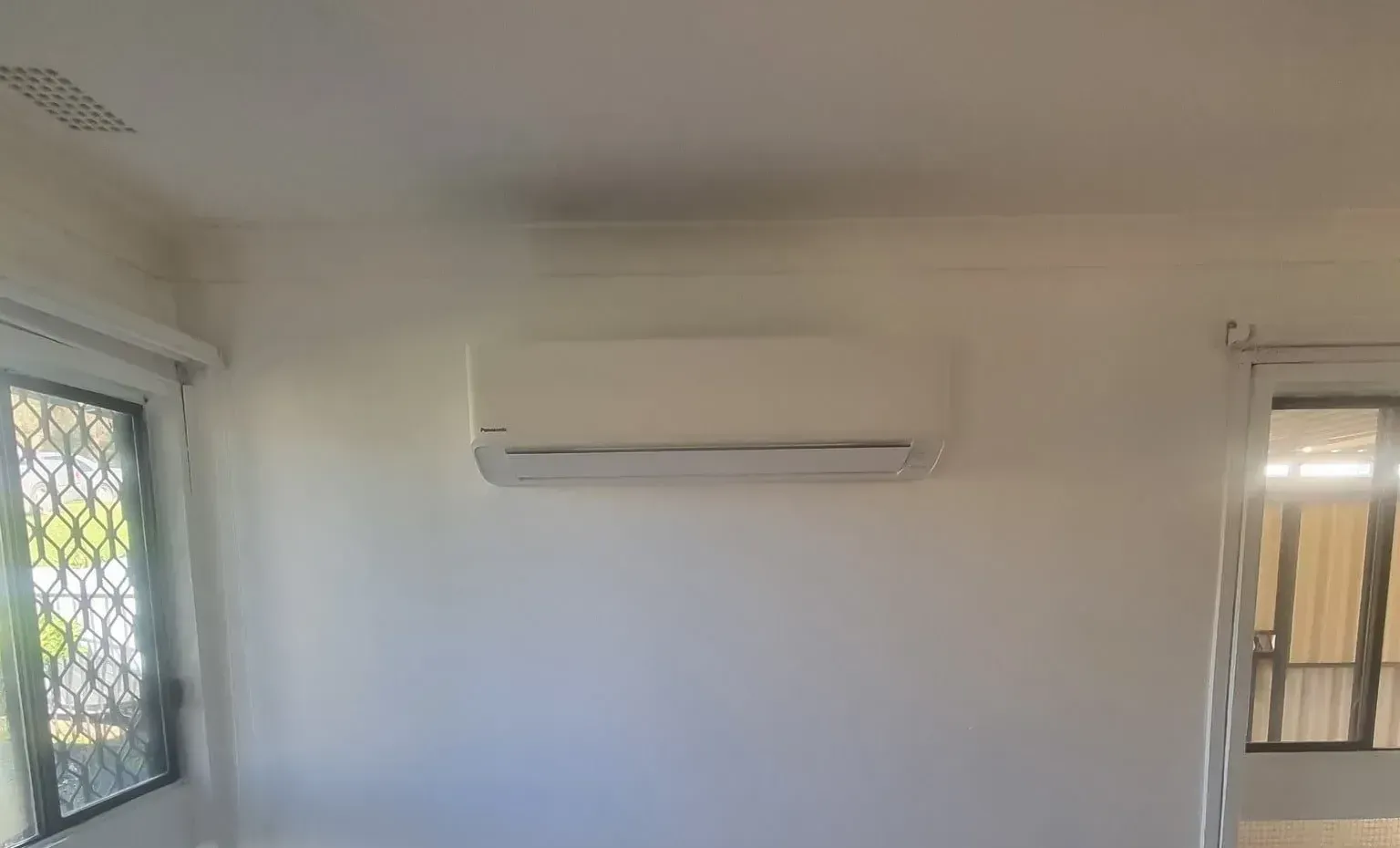 A Room With A Window And A Wall Mounted Air Conditioner — Rapidcool Air Conditioning & Electrical In Dapto, NSW