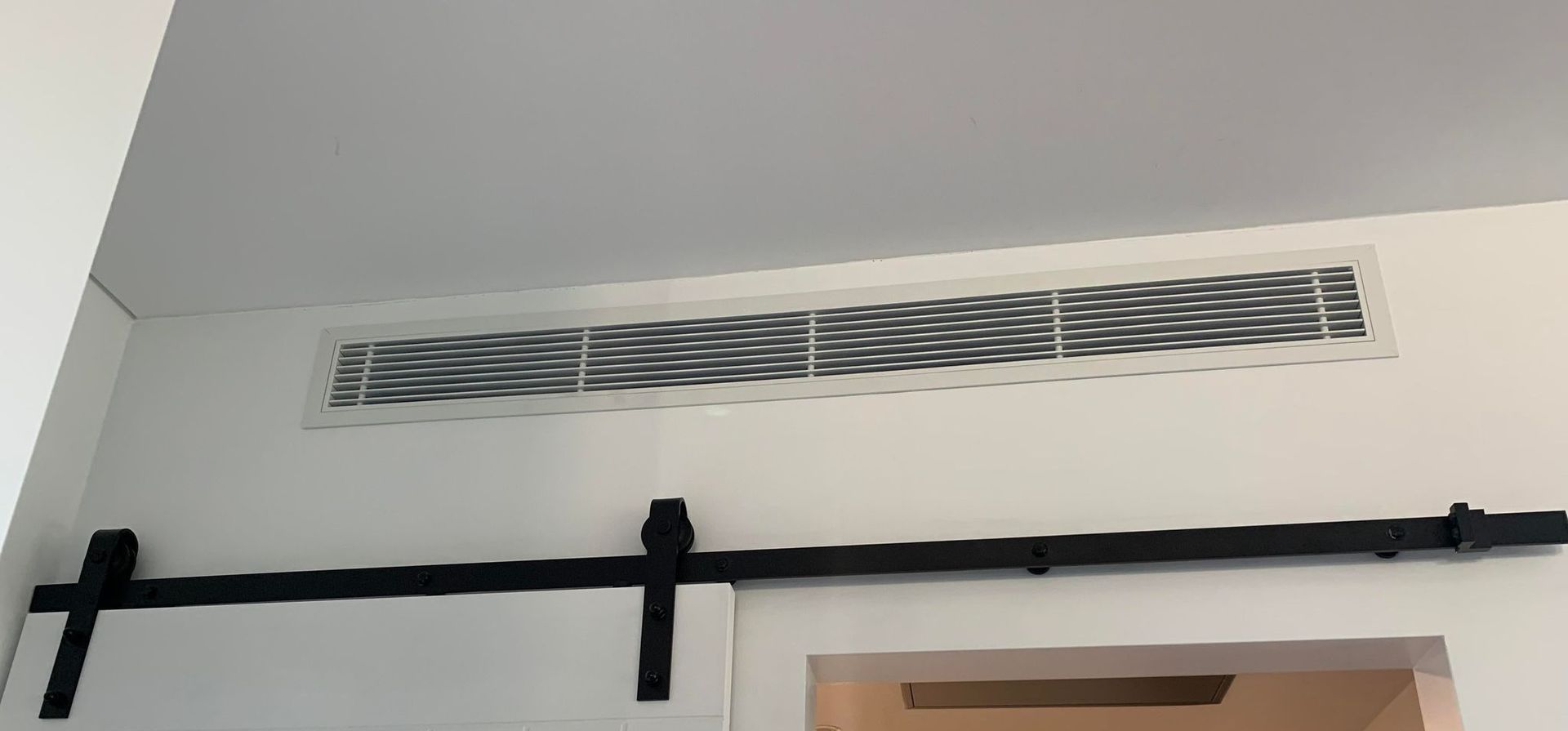 An Air Conditioner On A White Wall — Rapidcool Air Conditioning & Electrical In Thirroul, NSW