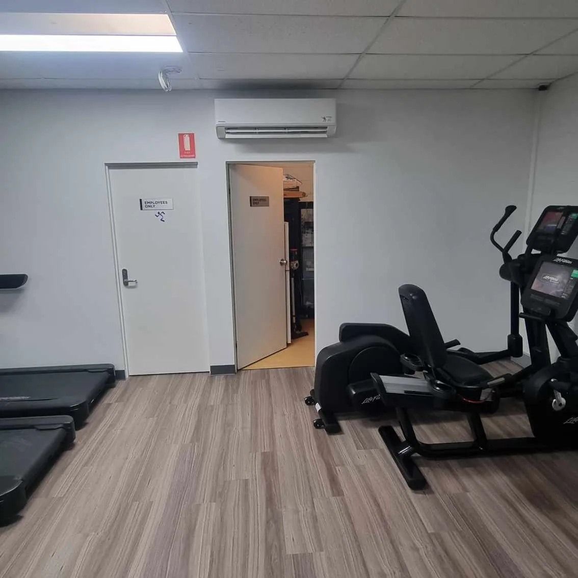A Gym With Treadmills, Ellipticals, And A Bench — Rapidcool Air Conditioning & Electrical In Dapto, NSW