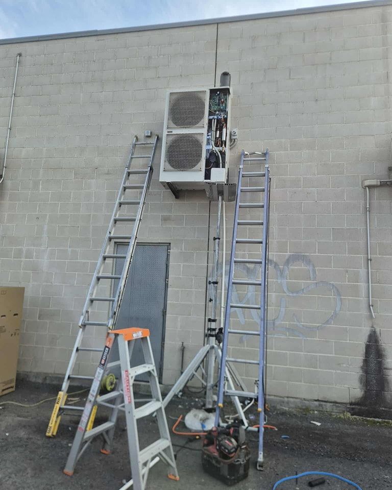 A Brick Wall With an Air Conditioning Unit Mounted — Rapidcool Air Conditioning & Electrical In Wollongong, NSW