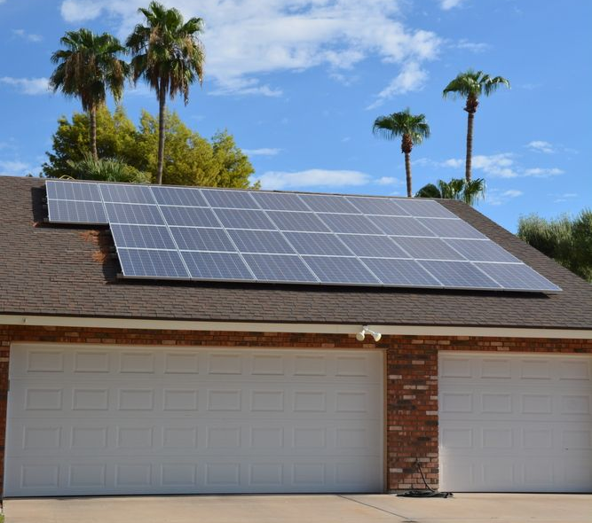 Solar Panels On A Brown Roof With Blue Skies And Palm Trees In The Background