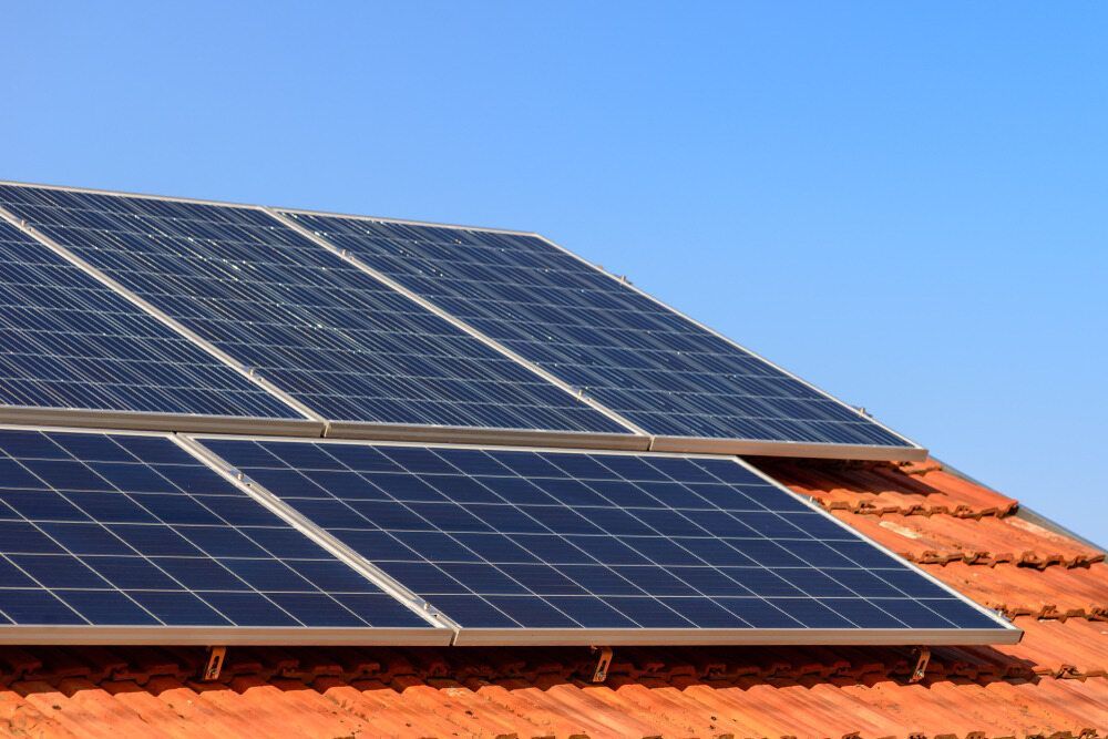 A Row Of Solar Panels Sitting On Top Of A Tiled Roof — Rapidcool Air Conditioning & Electrical In Albion Park, NSW