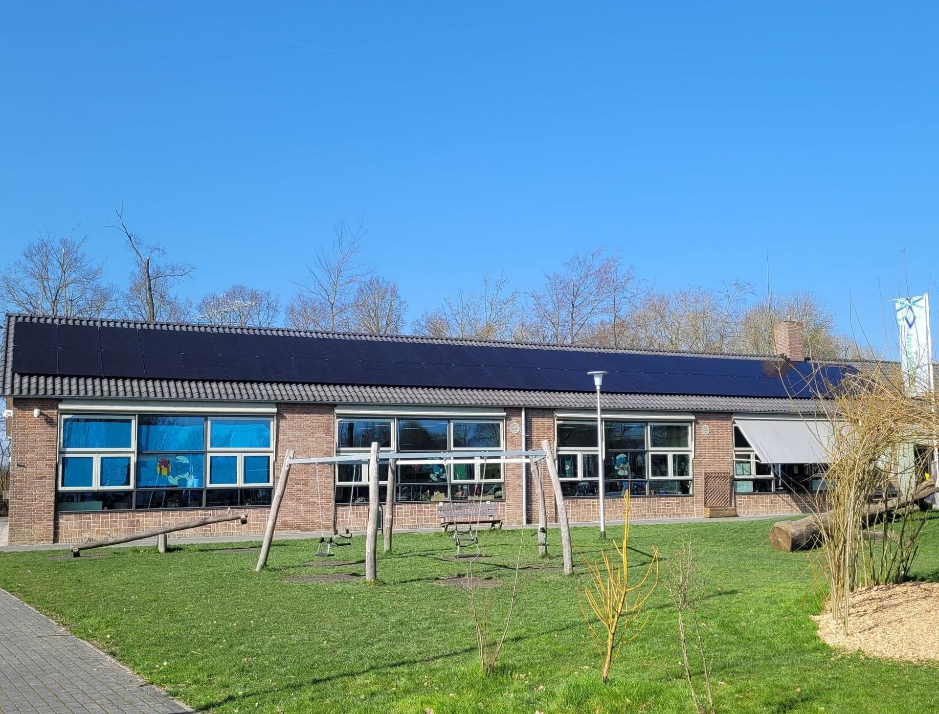 Een groot bedrijfsgebouw met veel zonnepanelen op het dak