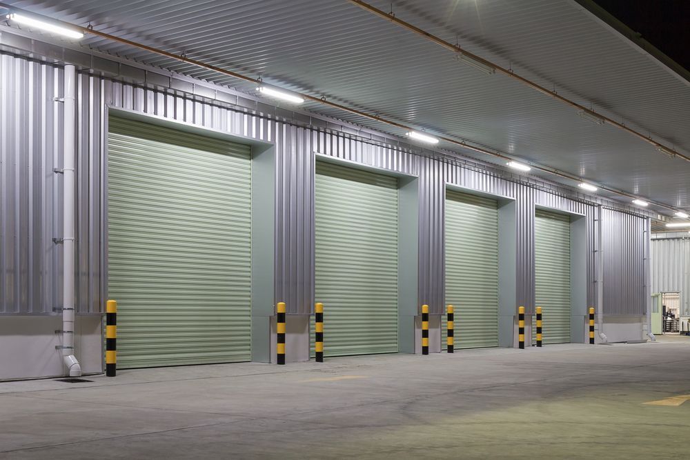 Warehouse Loading Dock With Four Closed Metal Roller Doors — All Things Industrial in Mackay, QLD