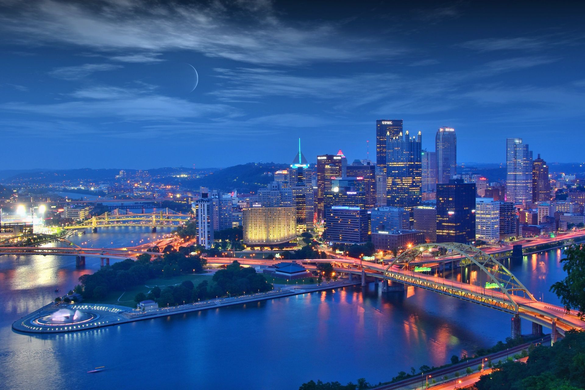 An aerial view of a city at night with a river in the foreground