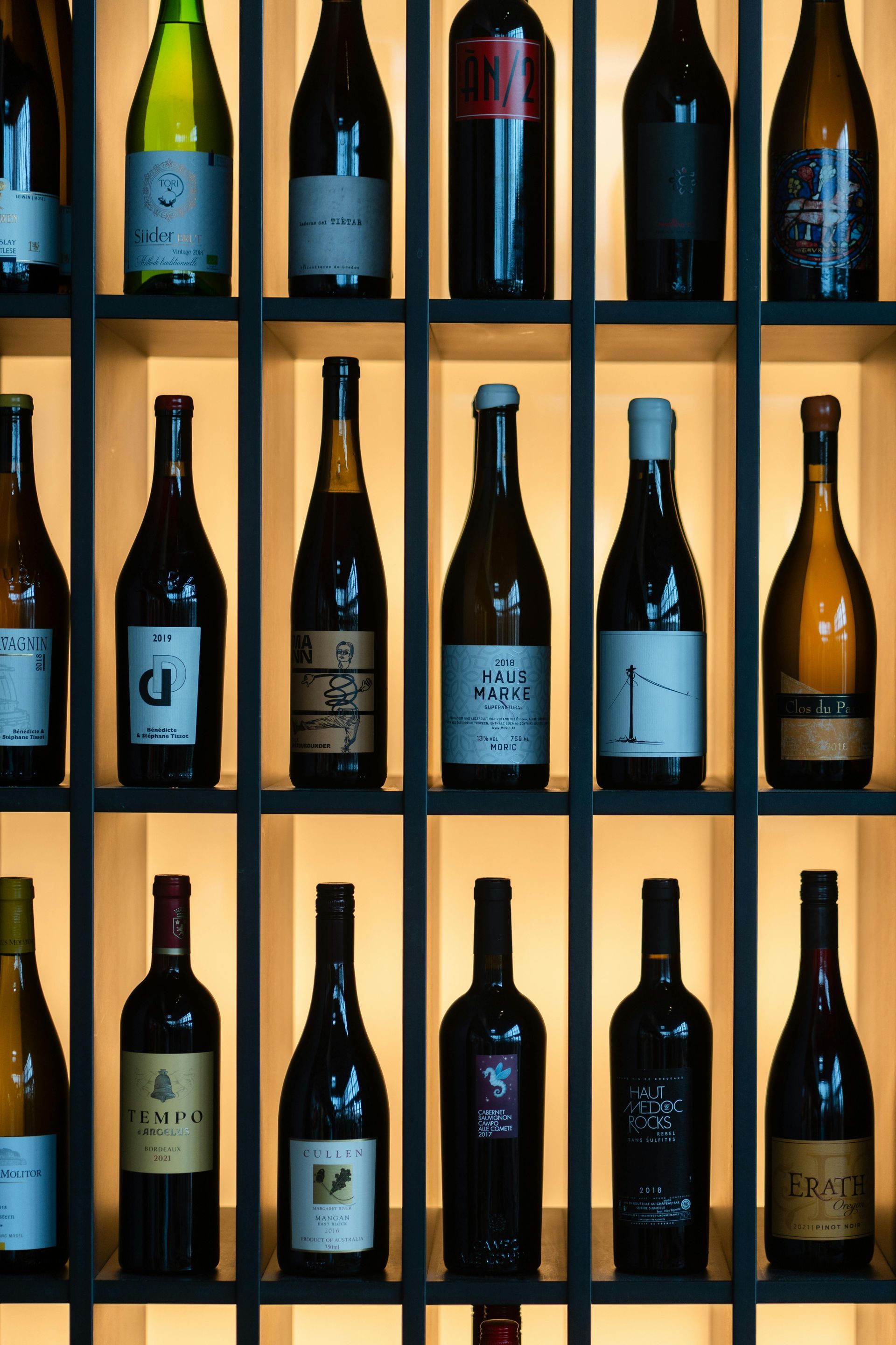 Many bottles of wine are lined up on shelves