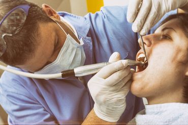Dentista che esegue la cura di un dente al cliente