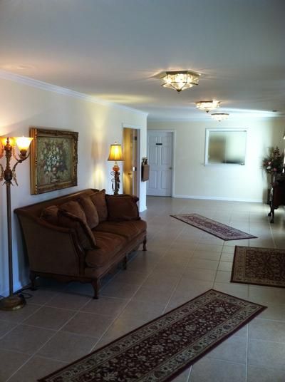 Interior lobby with brown sofa, rugs, and decorative lighting.