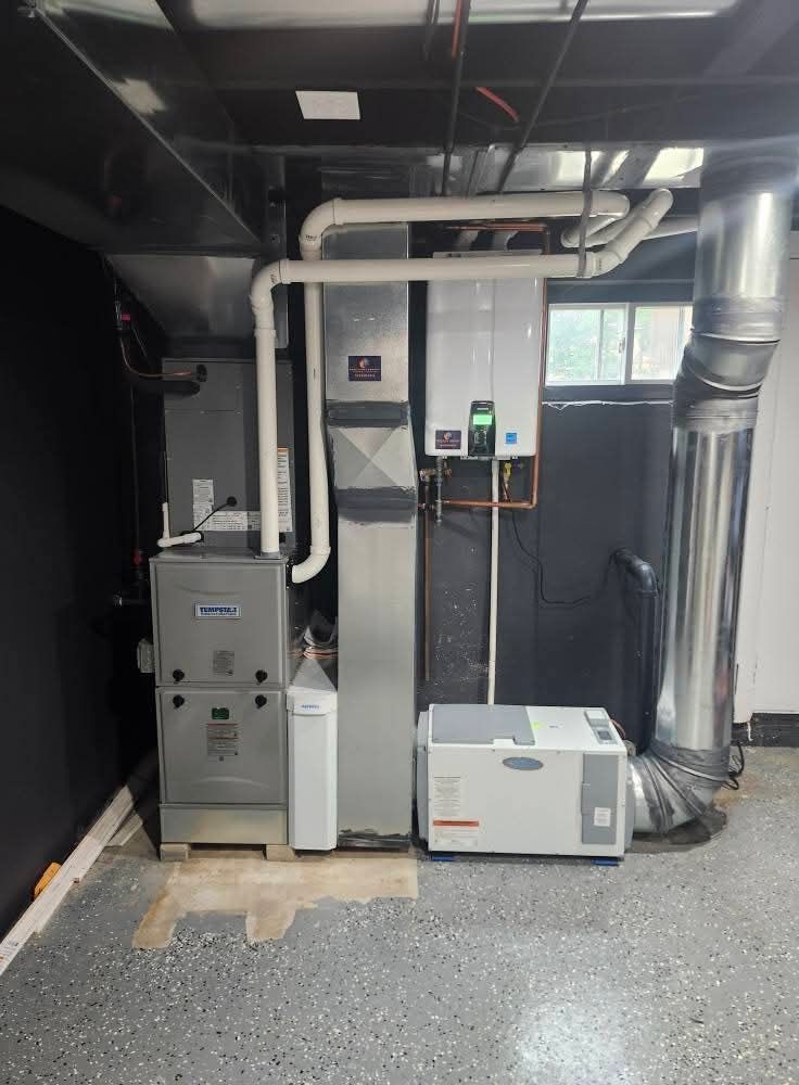 HVAC system in a basement. Includes furnace, water heater, humidifier, and ductwork. Gray and white appliances.