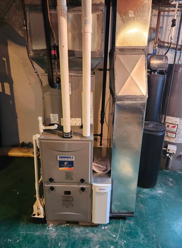 Furnace and air conditioning unit in a basement, with ventilation and water softener.