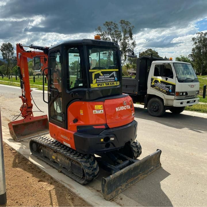 Orange Excavator is Parked Next to a Truck That Says Kubota — Donaldson Plumbing & Excavations in Kiewa, VIC