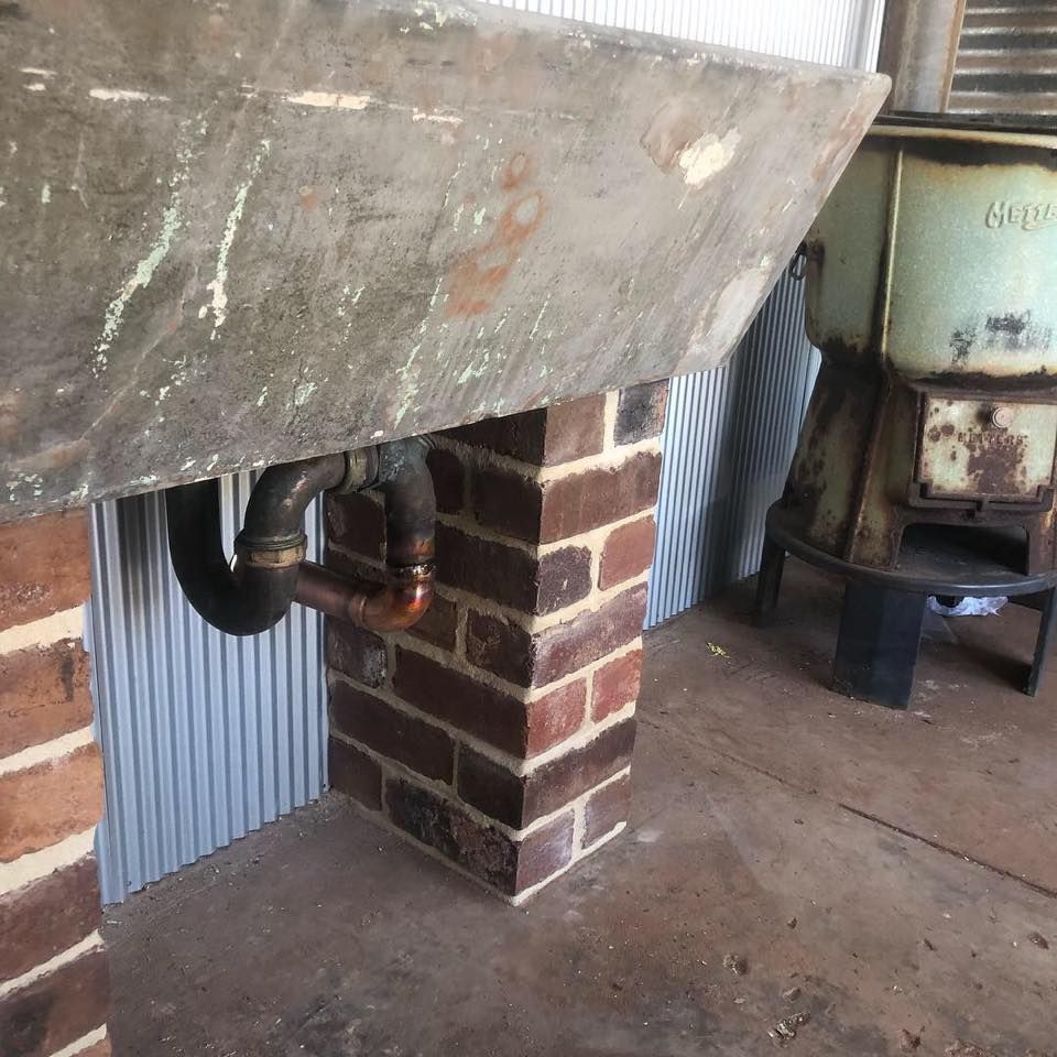 Brick Chimney With Copper Pipes Coming Out of It — Donaldson Plumbing & Excavations in Kergunyah, VIC