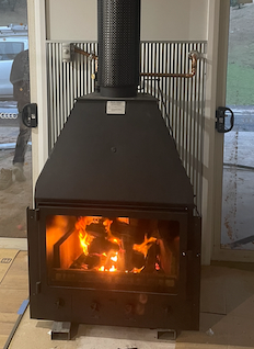 Wood-Burning Fireplace With a Lit Fire, and Black Exterior — Donaldson Plumbing & Excavations in Wodonga, VIC