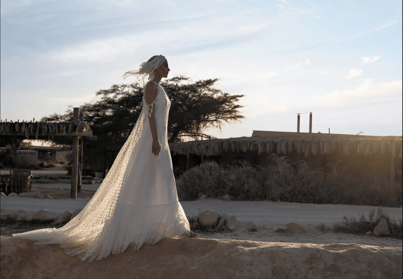 Eine Frau im Brautkleid geht durch die Wüste