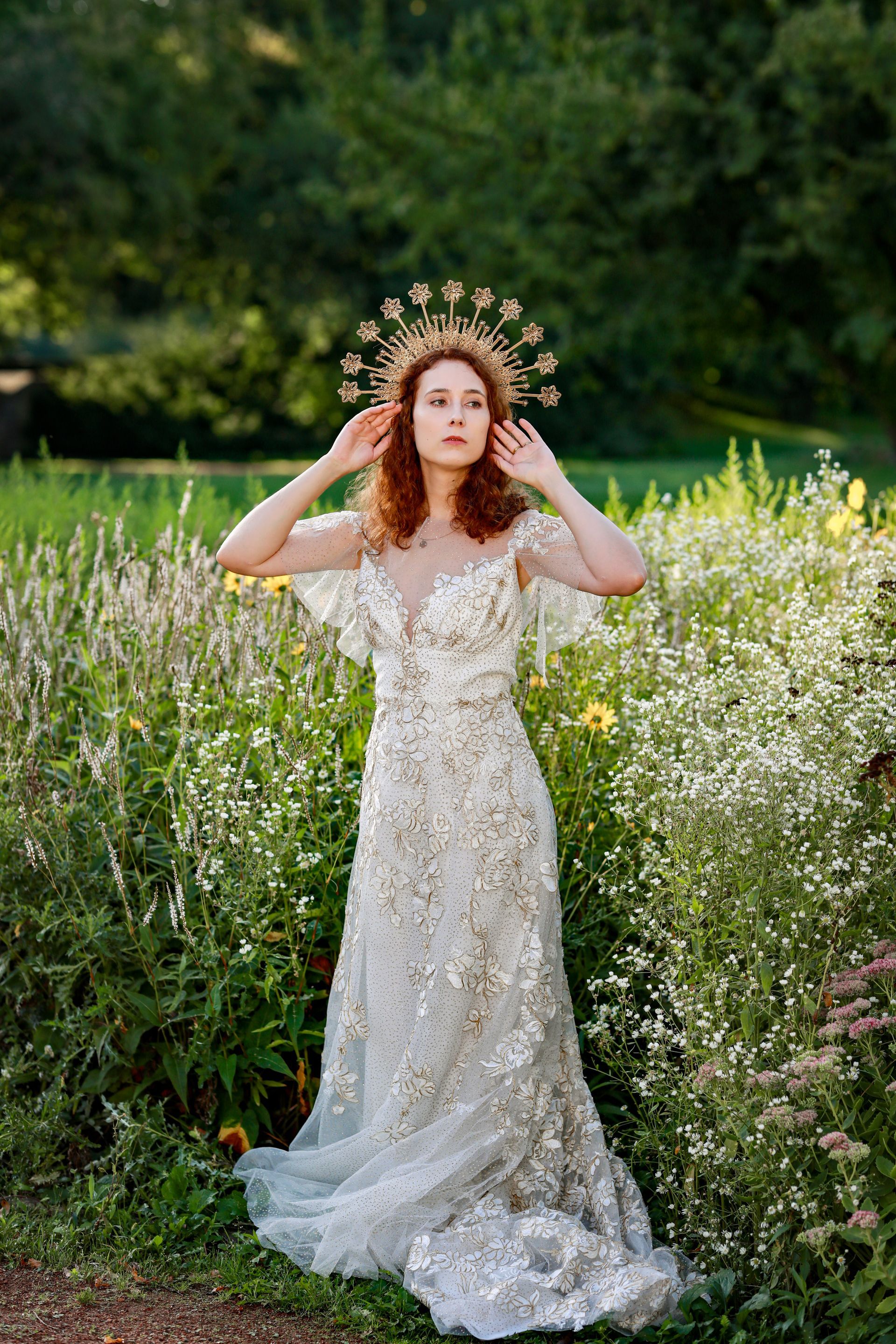 Eine Frau in einem Brautkleid steht auf einem Blumenfeld.