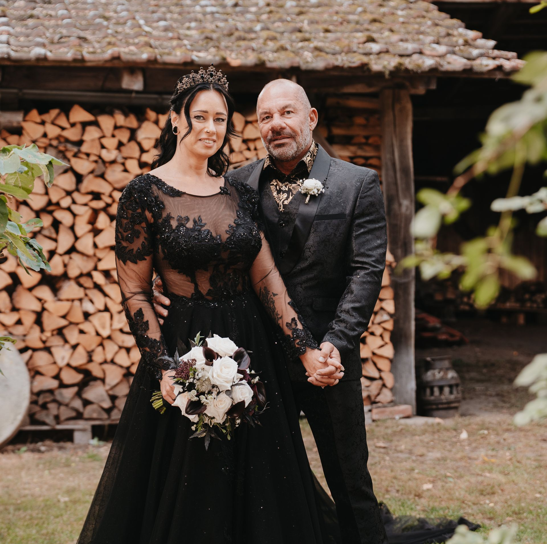 Eine Braut und ein Bräutigam sitzen auf einer Holzbank.