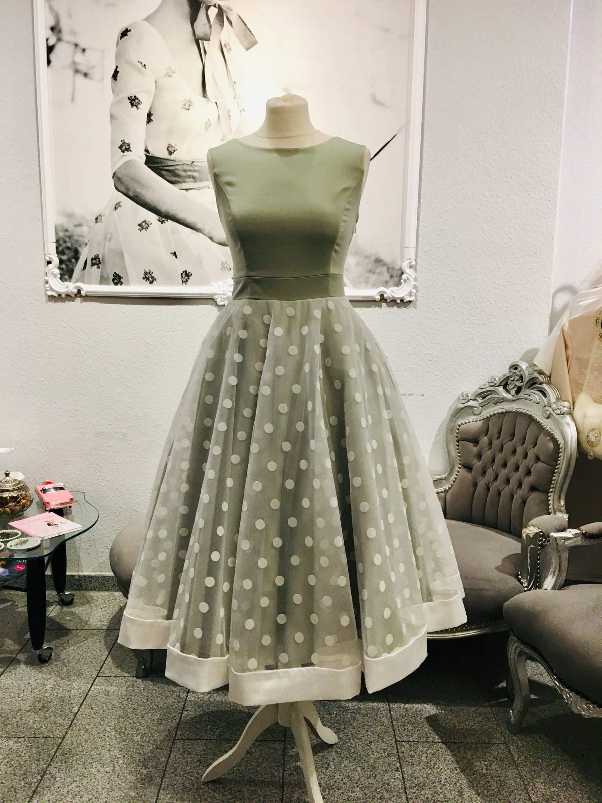 Eine Schaufensterpuppe trägt in einem Raum ein gepunktetes Kleid.