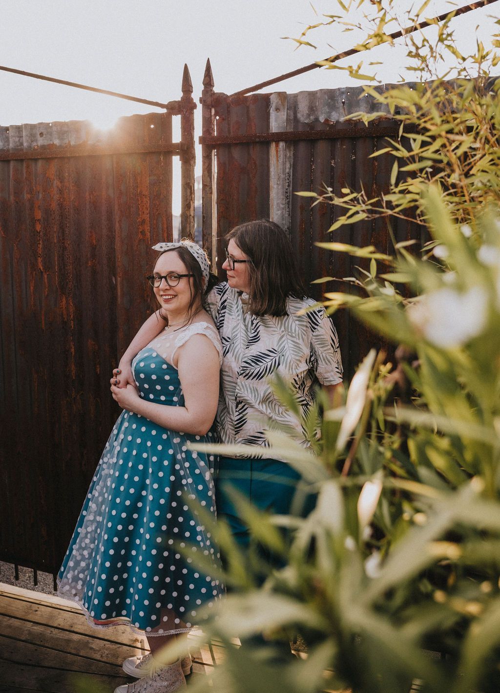 Eine Braut angelehnt an einem Oldtimer in einem Diner, in ihrem Rockabilly Hochzeitskleid.