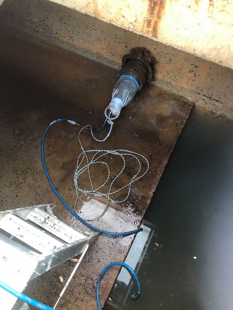 A Hose With a Bottle Attached to It is Connected to a Metal Pipe — FlowWise in Noosa Heads, QLD