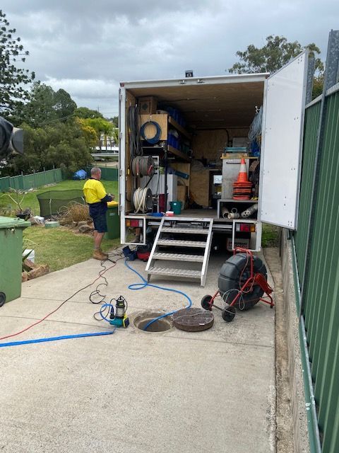 A Man is Standing in Front of a Drain Cleaning Truck — FlowWise in Buderim, QLD