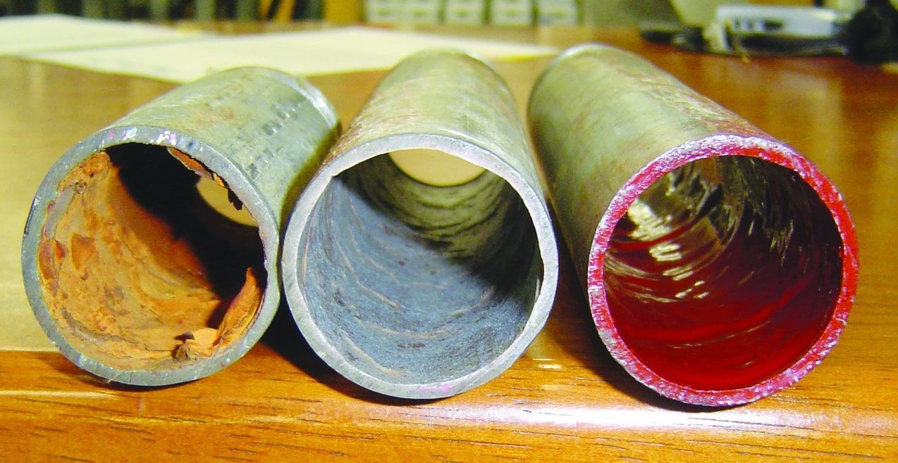 Three Different Types of Metal Pipes Are Sitting on a Wooden Table — FlowWise in Maroochydore, QLD