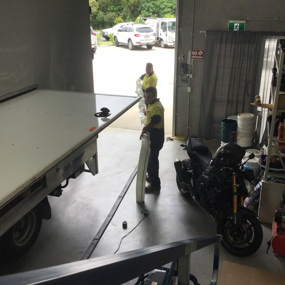 A Man is Standing Next to a Motorcycle in a Garage — FlowWise in Maroochydore, QLD
