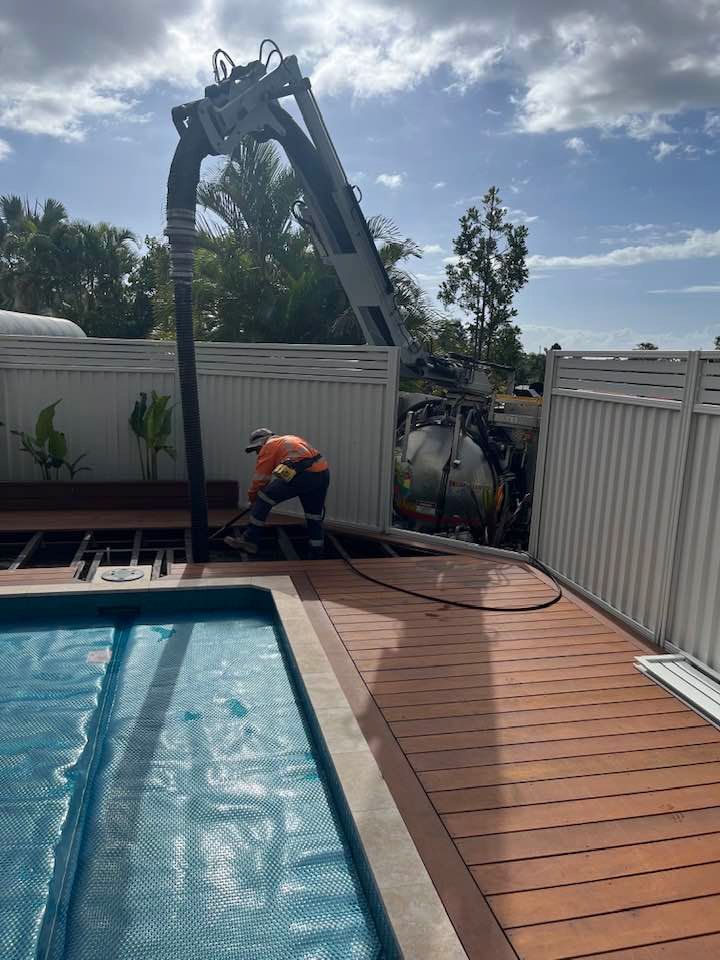 A Man is Working on a Deck Next to a Swimming Pool — FlowWise in Maroochydore, QLD