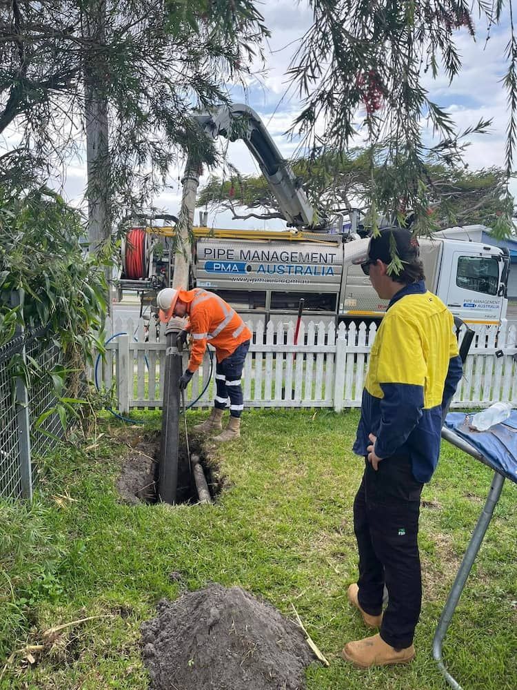 A Man is Standing Next to a Man Digging a Hole in the Ground — FlowWise in Maroochydore, QLD