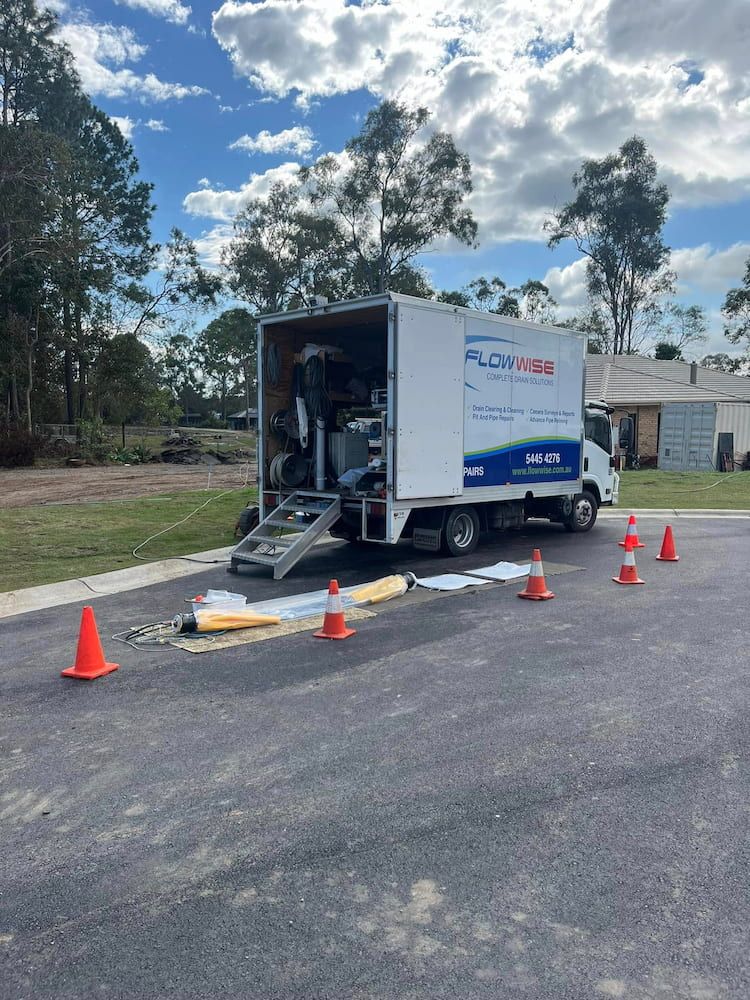 A White Truck is Parked on the Side of the Road Next to Orange Cones — FlowWise in Maroochydore, QLD