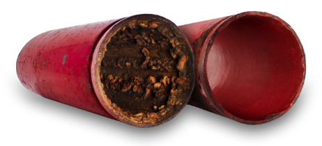 Cross-section of a red pipe heavily corroded on the inside, next to a clean red pipe of the same kind. — FlowWise in Maroochydore, QLD