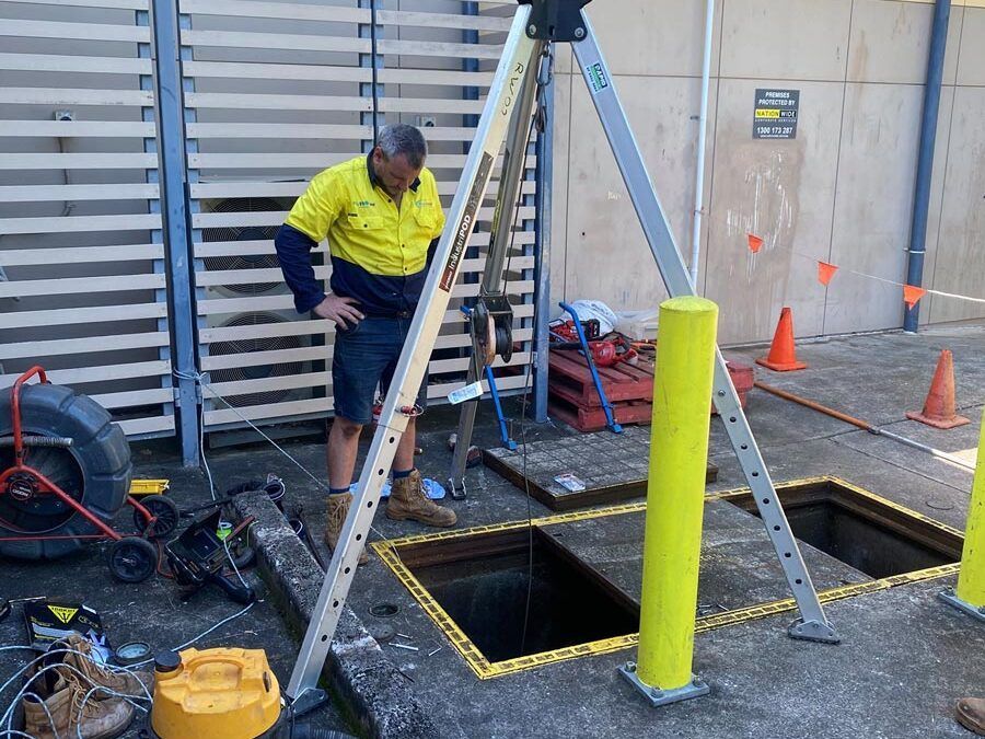 A Man is Standing Next to a Ladder Next to a Hole in the Ground — FlowWise in Maroochydore, QLD