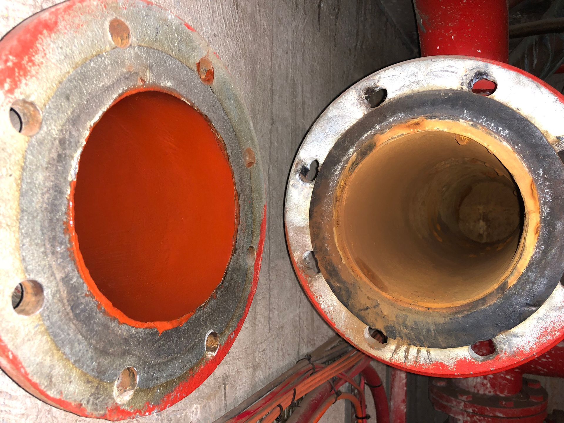 A Close Up of Two Red Pipes With Holes in Them — FlowWise in Maroochydore, QLD