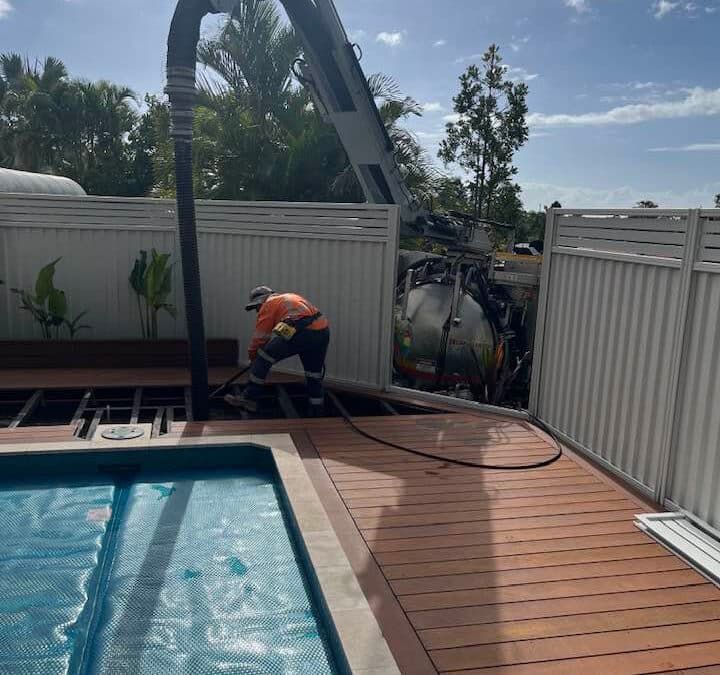 A Man is Working on a Deck Next to a Swimming Pool — FlowWise in Maroochydore, QLD
