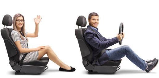 Woman waves from a car seat, man holds a steering wheel in another car seat, isolated on white.