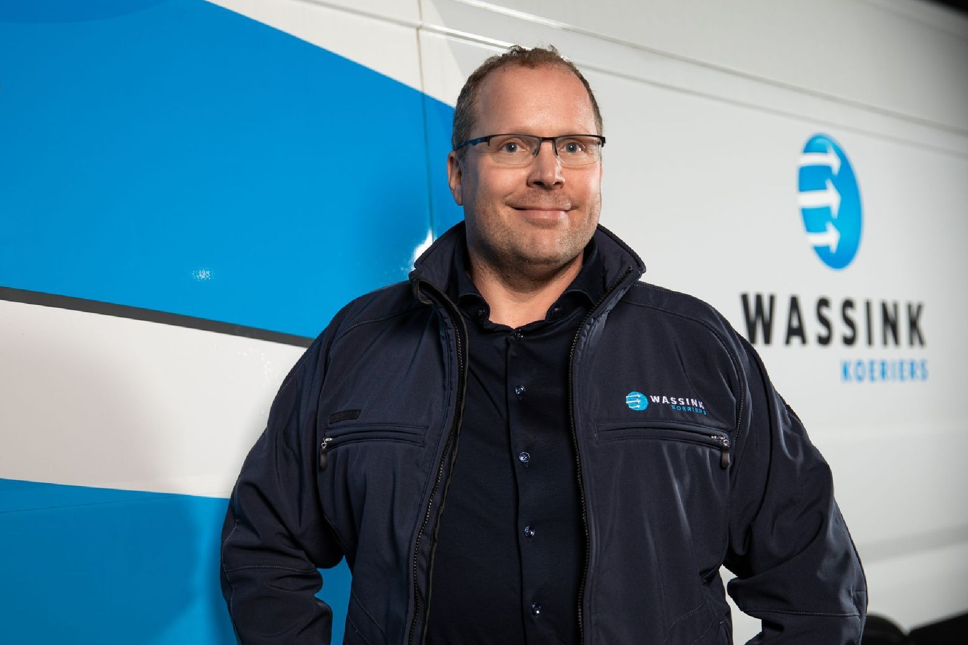 Een oudere man zit aan een bureau voor een computer.