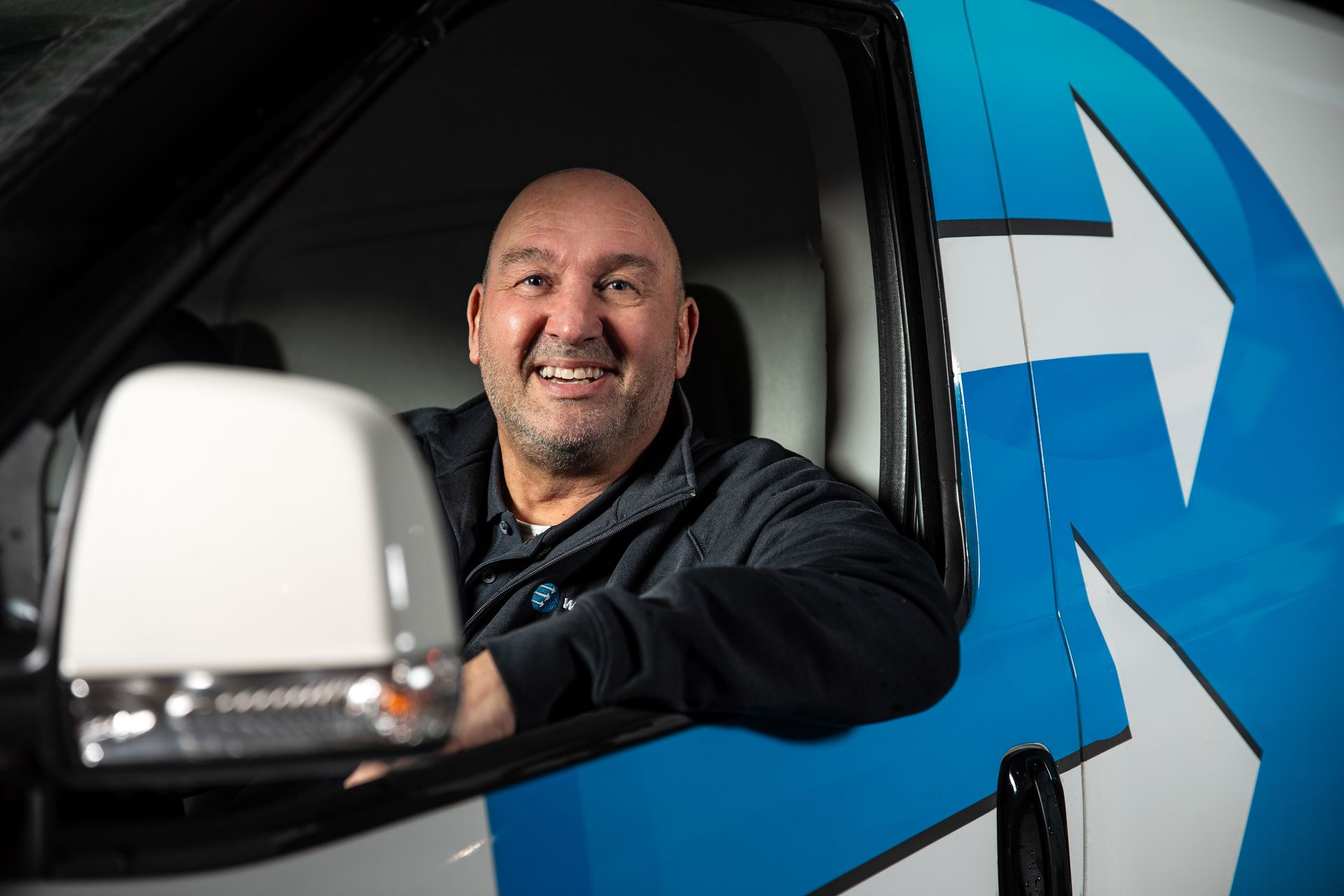 Een oudere man zit aan een bureau voor een computer.