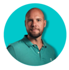 Een kale man met een baard draagt ​​een groen poloshirt.