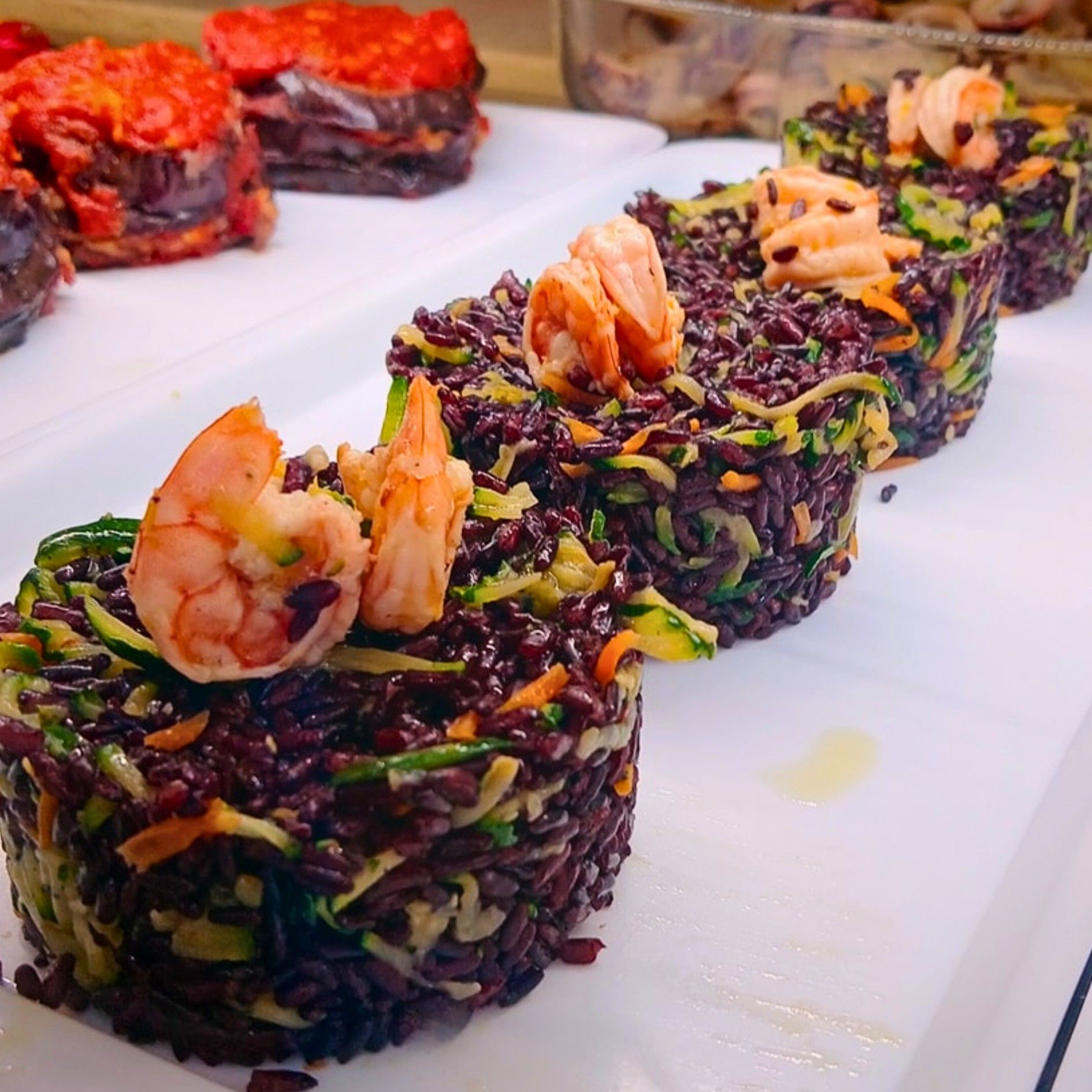 Un piatto di cibo con gamberi e riso sopra