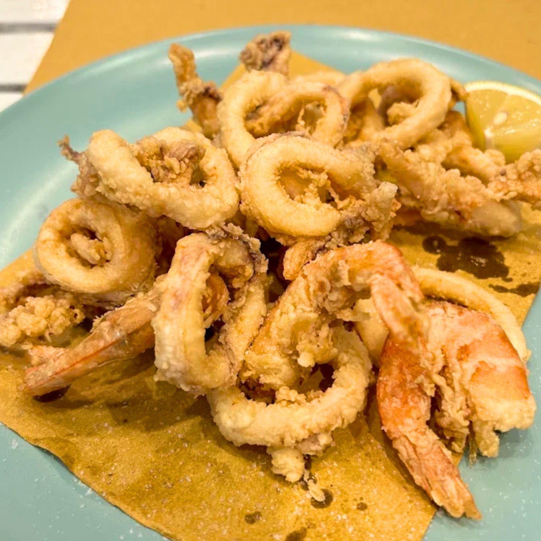 Un piatto blu condito con calamari e gamberi fritti