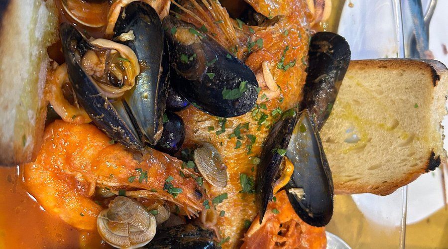 Un primo piano di un piatto di cibo con pane e salsa su un tavolo.