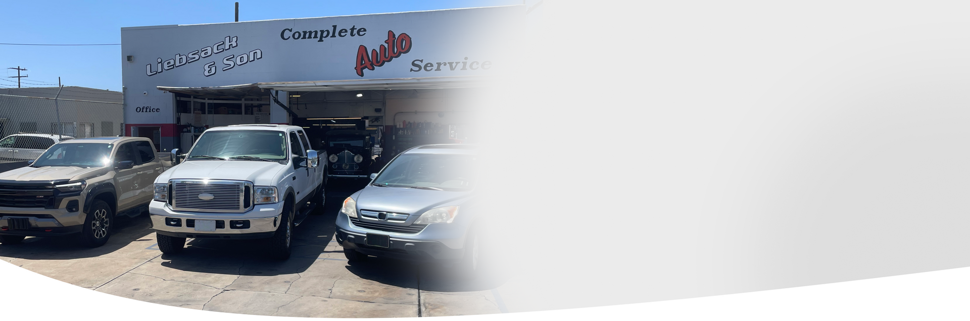 Two trucks are parked in front of a garage. | Liebsack Auto Services
