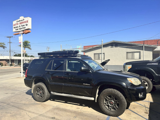 A black suv with a roof rack is parked in a parking lot. | Liebsack Auto Services