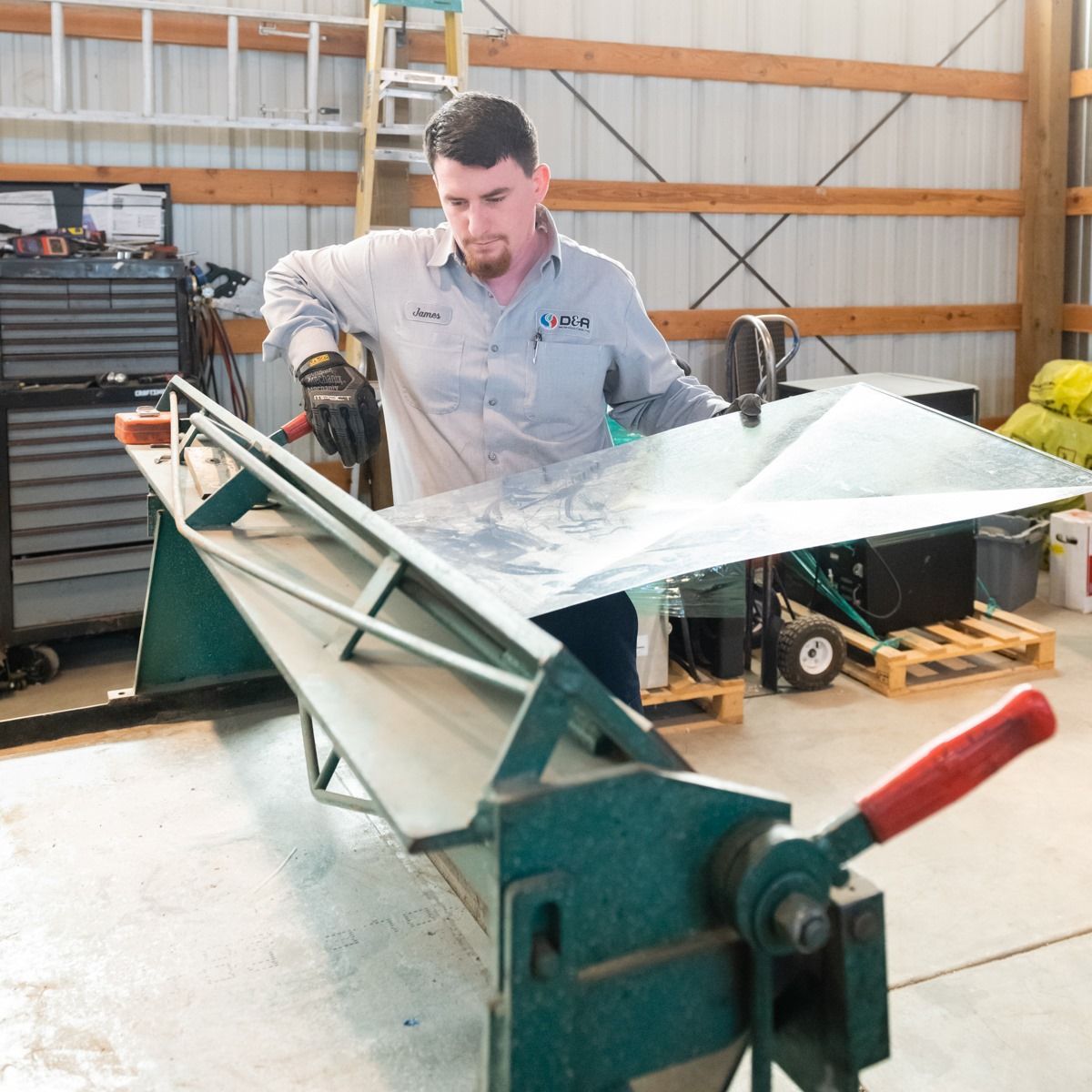 A man wearing a shirt that says lowes is working on a machine