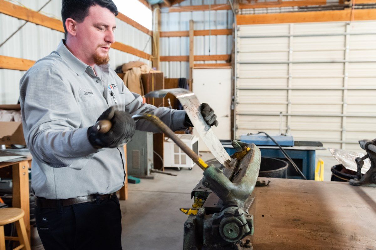A man is working on a machine in a garage.